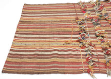 In Anatolian weaving traditions, such additions often carried protective or symbolic meaning. Knotted cords, dangling fibers, and small beads were believed to function as apotropaic elements, intended to ward off the evil eye and protect the household. These expressive embellishments transform the textile from a simple utilitarian weave into a more personal and talismanic object.