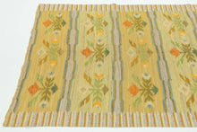 This Rölakan was handwoven in Sweden during the middle of the 20th Century.

A beautifully balanced Scandinavian flatweave featuring soft, luminous tones of straw yellow, pale green, sky blue, and warm ochre. The design is arranged in horizontal bands of stylized floral motifs, framed by subtle striped edges in an unmistakable nod to mid-century Swedish weaving traditions. The palette is intentionally gentle and airy, giving the piece a fresh, understated presence that works effortlessly in contemporary int