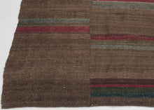 An early 20th century Dolpo blanket woven from handspun wool in the high Himalayan region of northwestern Nepal. Constructed from joined panels, the surface carries a quiet patchwork rhythm created by subtle shifts in tone and the intentional rotation of narrow striped bands.