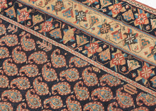 A beautifully composed Afshar rug featuring a classic allover boteh field, each sprouting motif rendered with crisp definition against a deep indigo (almost black) ground. The botehs are arranged in tightly organized rows, creating a shimmering, textile-within-textile effect that rewards close looking. Subtle shifts in dye tone animate the surface, giving the field a sense of depth and movement.

Framing the boteh lattice is a vibrant, floral border system of spiraling blossoms, stylized palmettes, and angu