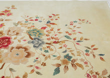 A luminous Chinese Art Deco rug with a spacious ivory field anchored by an asymmetrical flowering tree composition. Soft celadon, coral, blush, and muted gold tones float across the surface, creating an airy, painterly effect against the open ground.
