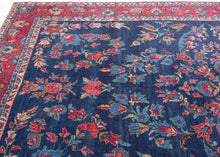 An elegant vintage Tabriz carpet distinguished by its unusually deep indigo-blue field and spacious floral drawing. A softly articulated central medallion anchors the composition, surrounded by scrolling vines, palmettes, blossoms and delicate boteh rendered in saturated shades of cornflower and sky blue, rose, coral, red, celadon, camel and ivory.