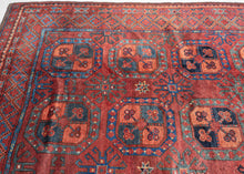 A handsome Ersari Turkmen carpet with a richly saturated madder-red field organized into rows of large octagonal guls, each quartered and filled with small floral devices. Between them, angular cruciform ornaments create a secondary lattice, giving the field an unusually energetic rhythm.