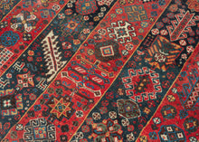 An exceptional Shekarlu rug with an unusually elaborate striped field, alternating saturated madder-red and deep indigo panels packed with an astonishing vocabulary of small motifs. Trees, rosettes, comb-like devices, lattices, geometric medallions, animals, and tiny human figures appear almost like a woven archive of tribal imagery, with scarcely an inch left unconsidered.