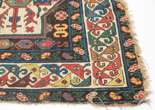 An extraordinary Armenian inscribed rug dated 1894, with a powerful sequence of geometric medallions set against a richly colored field of red, ivory, green, blue, yellow, and aubergine. The drawing is wonderfully individual, with bold hooked forms, small floral devices, and a lively multicolored border framing the composition.

Most compelling is the woven Armenian inscription, which appears to read:

“The rug of Satenik Abovian, in the year 1894.”