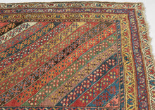 An exceptional Kurdish rug distinguished above all by its top-notch color and superb wool. The field is composed of lively diagonal bands, each carrying a different floral or geometric repeat and shifting through saturated brick red, deep indigo, grassy green, ivory, ochre, aubergine, and soft rose.