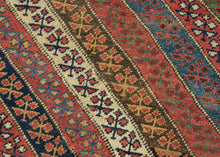 An exceptional Kurdish rug distinguished above all by its top-notch color and superb wool. The field is composed of lively diagonal bands, each carrying a different floral or geometric repeat and shifting through saturated brick red, deep indigo, grassy green, ivory, ochre, aubergine, and soft rose.
