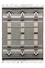 This Rollaken kilim was handwoven at Klockargårdens Hemslöjd in Sweden during the middle of the 20th century. It features a minimalistic geometric design woven with. an architectural feel. The palette of black, white, gray, olive and periwinkle is enhanced with marled yarn which softens the composition while giving it depth. Braided fringe at both ends complete the rug. Two sets of initials can be found "MG" on the bottom left and "KH" on the bottom right. The "MG" references textile artist Märtha Gahn  