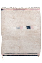 This rug combines tight handmade moroccan shag with modern aesthetics. A simple open cream field is unadorned other than one off-center row of square in pink, white, light and dark purple. Each color is represented greater saturation in the striped kilim ends on top in bottom. Great on the floor or even better up on a wall! moroccan middle atlas