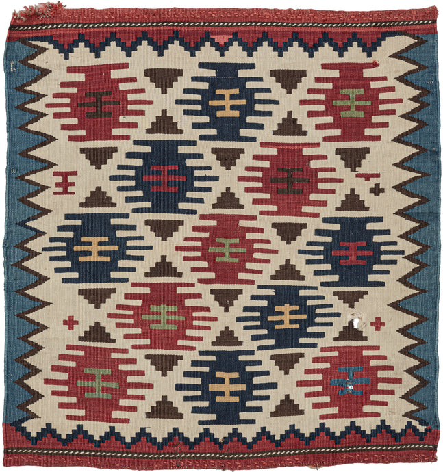 It features a field of red and blue stepped polygons and small brown triangles in various on a bright ivory ground.  The ivory field is framed by jagged zigzags around the perimeter and finished with thick bands of blue and red on the sides and ends respectively. May have been made as one side of a saddle bag. A small but impactful piece.
