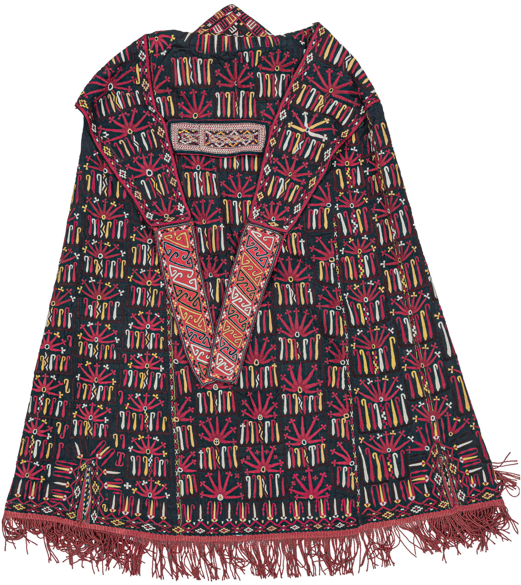  A chyrpy is a long robe of embroidered silk that Tekke women wear over the head and shoulders with false, decorative sleeves. These are ceremonial garments to be worn on special occasions.  This chyrpy features abstracted floral forms stitched in yellow, ivory aubergine and red silk on black ground. It is lined with cotton that is blockprinted with boteh and scrolling leaves.