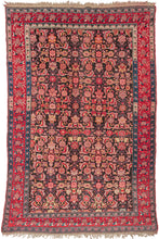 This Antique Karabagh Rug features an all over large scale herati pattern in reds, pinks, purple, green yellow and ivory on a brownish/black ground. The dark ground has oxidized adding dimensionality to the piece. Framed by a main border of cabbage roses characteristic of this type and floral minor borders with highly contrasting abrash which adds significant interest to the composition