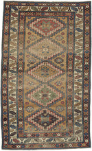This Antique Kazak Rug features large latch-hooked medallions on a rare yellow ground that is full of various randomly placed rosettes and star-filled octagons. Framed by a classic leaf and calyx main border and minor borders of polychrome rosettes. 