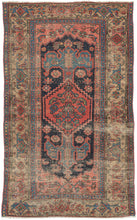 This Kurdish rug was handwoven during the early 20th century in Northwest Iran.  It features a soft red central medallion floating atop an open midnight blue field. A variation of the herati design can be found in both the medallion and the coral cornices. The meandering palmette border sits on a camel ground and is framed by two thin blue minor borders.