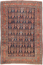 This Bidjar rug was handwoven during the early 20th century (1925-1950) in Northwest Iran.  It features an all-over design of polychrome forms reminiscent of cypress trees in various reds, blues, yellows and pinks on a deep navy ground. Each tree form is filled with a trio of botehs at its center. Framed by a rich red main border that is flanked by energetic turquoise minor borders that pull turquoise accents from the field and invigorate the whole composition.