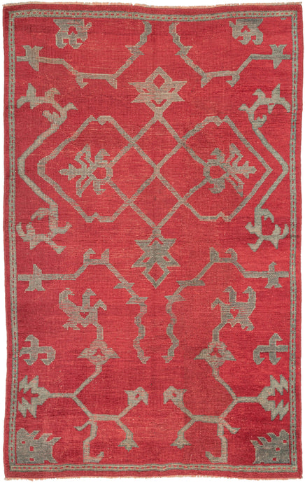 This Oushak was handwoven during the 19th century in Western Anatolia.  This elegant rug features a simple yet dramatic asymmetric design of curling vines, palmettes and abstracted fantastic creatures. A well spaced large scale field patter with a limited palette of a rich royal red and two tones soft blue framed by a thin border.