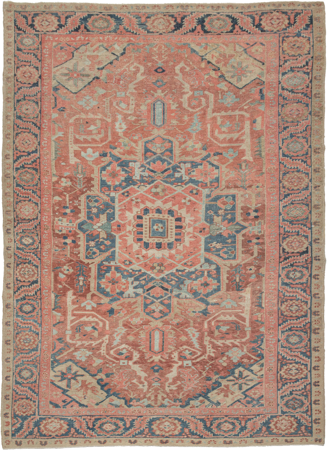 This Baby Serapi Rug features a classic Heriz patterning with a geometric central medallion on a patinated red ground. The four cornices mirror the design from the medallion in a different color combination.