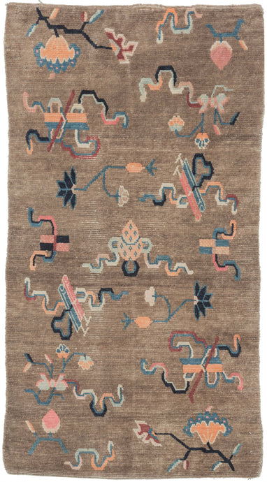 This Khaden was handwoven in Tibet during the early 20th century.   It features an open field of various whimsical cloudbands and other abstracted shapes and floral motifs. A wonderful palette of maroon, pink, orange, indigo and sky blue floats above the camel ground. The format and design suggest use as a 