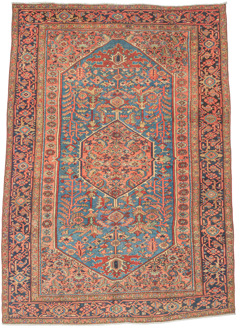 HERIZ
It features an atypical medallion-and-field composition centered around a coral octagonal medallion filled with angular palmettes and rosettes. The surrounding field is rendered in a softly abrashed sky-to-steel blue with scrolling vinery, serrated leaves, and stylized blossoms. The spandrels echo the motif density of the field yet shift toward coral and salmon tones that warm the overall composition. 