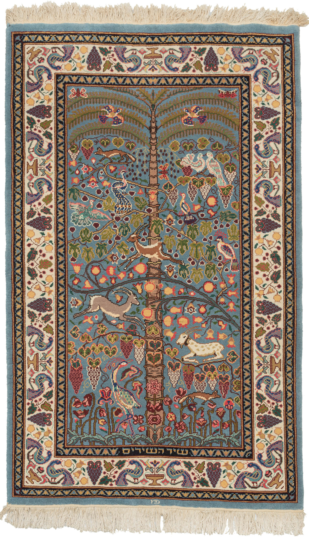 This Bezalel rug was handwoven in Israel during the late 20th century.   It features a tree of life design r. Framed by a border of alternating peacocks flanking vases. 