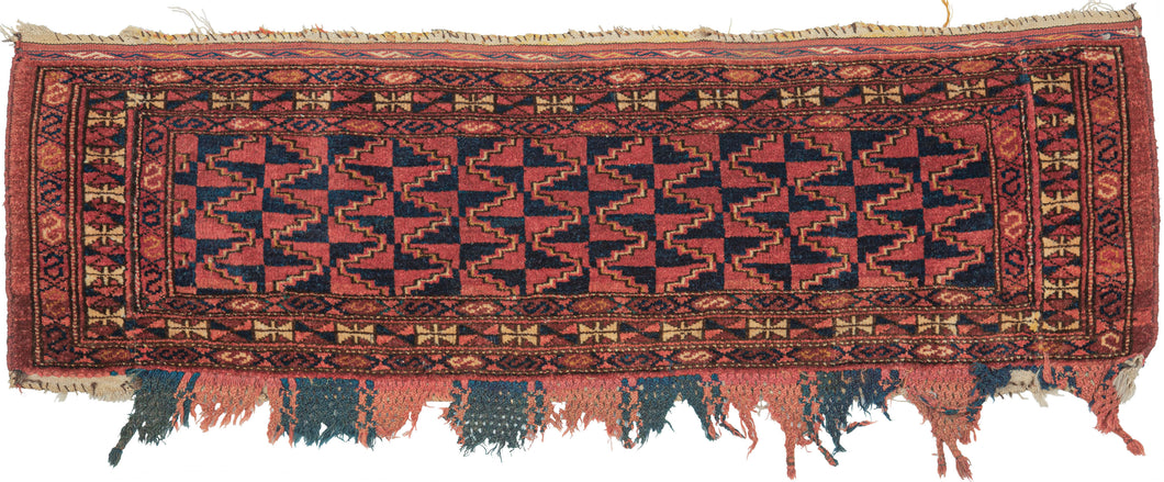 Trapping was handwoven by Ersari Turkmen in middle Amu Darya region of Central Asia during the 20th Century.  This trapping features an all over design of stepped diamonds in alternating earthy red and deep navy which is tightly rendered to hypnotic effect. macrame fringes that alternate between madder red and indigo. Likely made to hang on the wall or for a pack animal. 