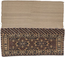 Turkmen chuval handwoven by Yomud Turkmen Turkmenistan during the early 20th Century.  Kepse güls in soft pink, ivory and navy on an open aubergine ground. geometric rosettes flanked by "running dog" or sawtooth minor borders. A chuval is a large storage used to both transport and store belongings. This example has the original flatwoven backing still intact and attached which is less common. The kilim was woven using undyed wool and displays a wonderful natural striation reminiscent of desert sands. 
