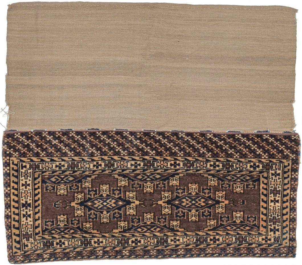 Turkmen chuval handwoven by Yomud Turkmen Turkmenistan during the early 20th Century.  Kepse güls in soft pink, ivory and navy on an open aubergine ground. geometric rosettes flanked by 