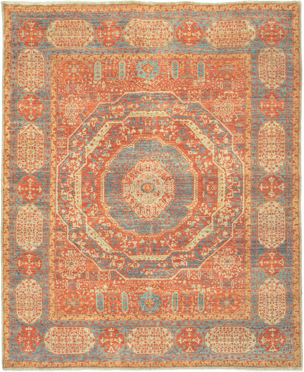 This Mamluk design rug was woven in India during the 21st century.  It features the distinctive patterning and color palette of classical Mamluk rugs. Mamluk rugs are a type of rug that was woven in Egypt during the 15th and 16th centuries. The graphic central medallion is formed of concentric shapes that gives the rendering a kaleidoscopic feel. Soft but lively tones of reds, blues, golds and greens are both striking and harmonious.