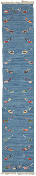Blue tulip motif kilim runner featuring a repetition of delicate polychrome tulips around a blue field. The tulips are finely woven of handspun wool in naturally dyed tones of yellow, green, brown, red, and pink and float upon an indigo field. The indigo background vibrates with each natural variation giving it a simple and straightforward presence, as well as a special feeling.