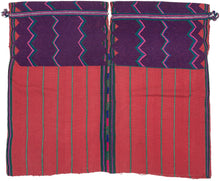 A bold highland huipil woven with striking contrast of deep purple and brick red. The upper section is patterned with vivid zig-zags in pink, green, and turquoise, while the lower body panels feature a calmer striped red ground. Woven on a backstrap loom, this piece balances geometric energy with grounding simplicity, making it both a traditional garment and a statement textile.