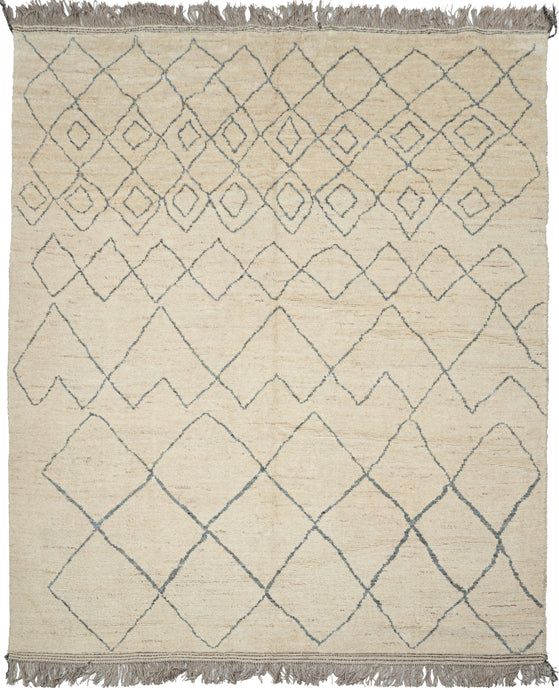 This Moroccan-styled rug was woven during the 21st century in Afghanistan.  It features an idiosyncratic pattern of diamond lattices. that have the feel of pencil quickly scribbled on paper. A simple palette of soft bluish gray lines which almost appear scribbled upon the shaggy cream ground. Woven of hearty, hand-spun Afghan wool giving it durability and extra heft not commonly found in the Moroccan weaving usually associated with this patterning. 
