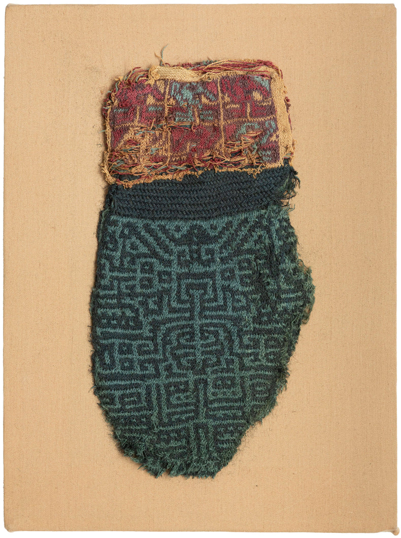 This Pre-Columbian textile fragment dates to the Wari period (circa 600–1000 AD) and is believed to be a panel from an elite tunic, serving as a form of rank insignia.

The design features a bold, labyrinthine geometric motif in tone on tone indigo and turqoise offset by remnants of a multicolor section in cochineal red, gold, and turquoise. These complex patterns are emblematic of Wari statecraft, where textiles conveyed status, authority, and identity. Technically, this piece exemplifies the Wari mas