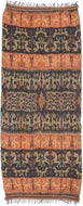 An Indonesian cotton ikat from Sumba with contrasting horizontal bands of deep indigo and warm rust. Stylized animal and ancestral motifs emerge rhythmically across the dark ground, their forms softened by the characteristic feathered edges of the resist-dye technique.