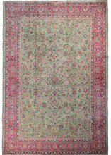 Keshan featuring an array of lively floral spray and detailed palmettes in pinks, blues and ivory atop a rare mint green field. The design has a central focus, but not quite a central medallion. A wide pink border encompasses the piece with an equally intricate pattern of scrolling leaves and "flaming" palmettes.
