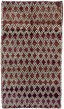 This Marmoucha rug was woven in the Middle Atlas mountains during the 20th century.  It features a tight diamond lattice design in green and white on grape ground. The purple tone shifts throughout the rug deeply saturated to soft and faded. The perimiter is neatly framed by a thin line.  