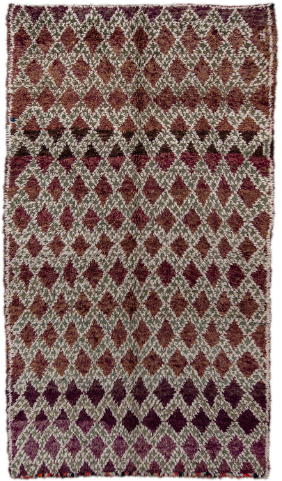 This Marmoucha rug was woven in the Middle Atlas mountains during the 20th century.  It features a tight diamond lattice design in green and white on grape ground. The purple tone shifts throughout the rug deeply saturated to soft and faded. The perimiter is neatly framed by a thin line.  