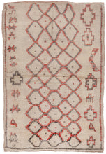 This Beni Ourain rug was woven during the late 20th century in the Middle Atlas Mountains of Morocco.  It features a central column of abstracted diamonds that is flanked by simple protection symbols on either side. Fun and funky in faded reds and blacks on a cream ground.