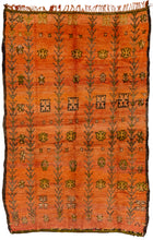 This Boujad rug was woven in the Middle Atlas mountains of Morocco during the 20th century.  It features totemic vegetal columns that alternate with various rosette like protection symbols in brown, green and  ivory on a vibrant Dutch Orange ground. Neatly framed by a thin dark brown perimeter. In rare hard to come by dimensions, a real statement piece. 