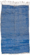 This Beni Ourain rug was woven in the Middle Atlas mountains during the 20th century.  It features a electric blue  ground that appears solid at first glance but with very nuanced shifts in tone. Would add a nice pop of color and energy to any room.