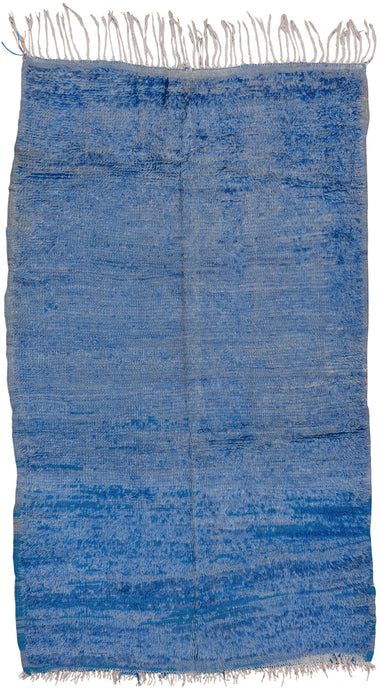 This Beni Ourain rug was woven in the Middle Atlas mountains during the 20th century.  It features a electric blue  ground that appears solid at first glance but with very nuanced shifts in tone. Would add a nice pop of color and energy to any room.