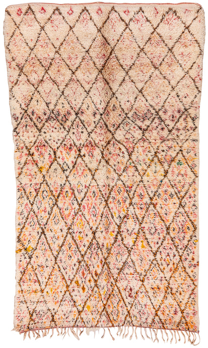 This Beni Mguild rug was handwoven during the late 20th century in the Middle Atlas Mountains of Morocco.  It features a diamond lattice design full of small dash marks and simple motifs. Primarily rendered in black, yellow and red on a cream ground but with fun moments of blue and green. 