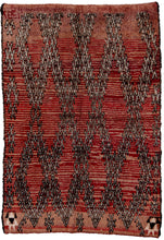 This Moroccan rug was woven in the High Atlas mountains of Morocco during the 20th century.  It features a barbed wire lattice diamond design on variegated purple ground. The deep contrast of the variegation gives it an organic striping. The lattice is flanked by evil eyes symbols on either side and the date "1997"is woven into the rug. 