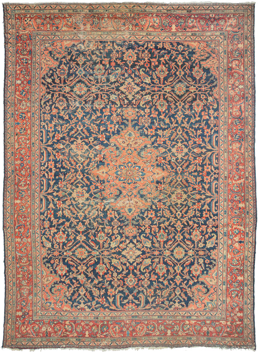 Large antique blue mahal rug featuring a central medallion and four cornices rendered in a lovely coral tone on a blue field of scrolling vines with palmettes in blues, red, seafoam, and gold. The main border is composed of scrolling vine work on a soft crimson ground. The wear to the foundation adds a little edge to the ornate patterning.