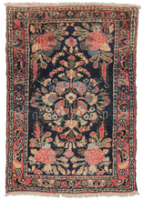 Mehraban doormat rug featuring an inky-blue field, which contrasts beautifully with the bubblegum pink of the flowers. The central medallion expands into four rose blossoms in the corner. The motifs are outlined in white, which lifts up the design. The border is a funky floral meander, on a pink field.