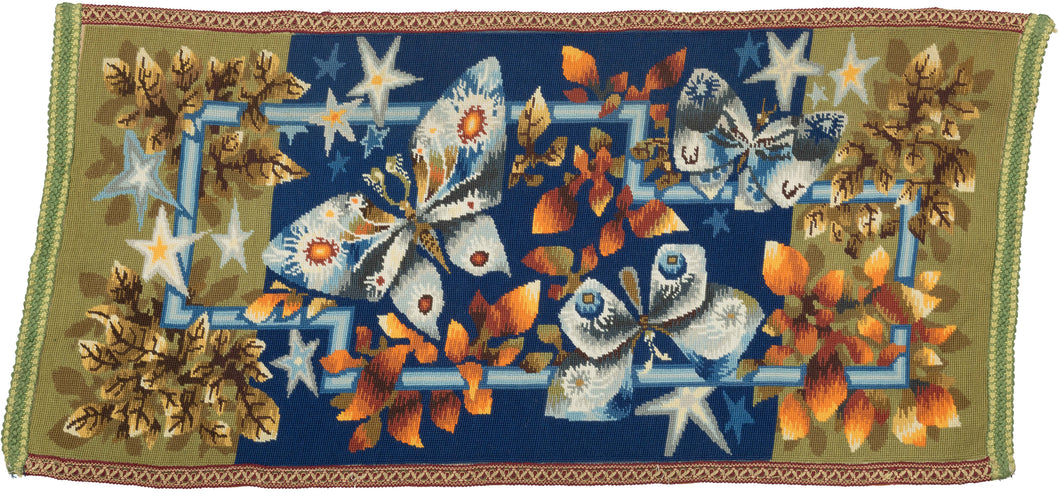  needlepoint rug handcrafted in Europe.  Features a nighttime scene of foliage, moths and stars that wrap both above and behind a blue rectilinear form. It is simple and straightforward yet still striking in its warmth and beauty. The forms are impeccably executed and stand out against the backdrop that shifts from olive green to indigo and back to olive green. Look closely to see the renderign of shadows behind the leaves stars. Wonderful use of shading and dimensionality.