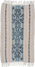 This ikat was handmade on the island of Sumba in Indonesia during the middle of the 20th century.  Ikat is a warp resist dyeing technique similar to "tie dyeing". It features a palette of ivory, soft pinks, yellow and rich indigo blue. A variety of symbols are found on the cloth including various figures and animals most prominently people riding horses.