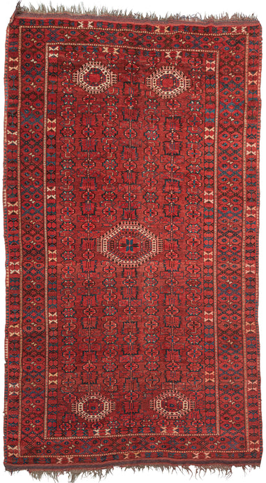 Beshir Turkmen rug handwoven along the Amu Darya river in Central Asia.  It features one large central medallion and four smaller medallions on the top and bottom of this wide and narrow format which is common for type. The medallions sit at an all over design of an abstracted herati variation with wide leaves, rounded rosettes and arrow like forms. various borders of tulips, evil eyes and eight pointed rosettes. 