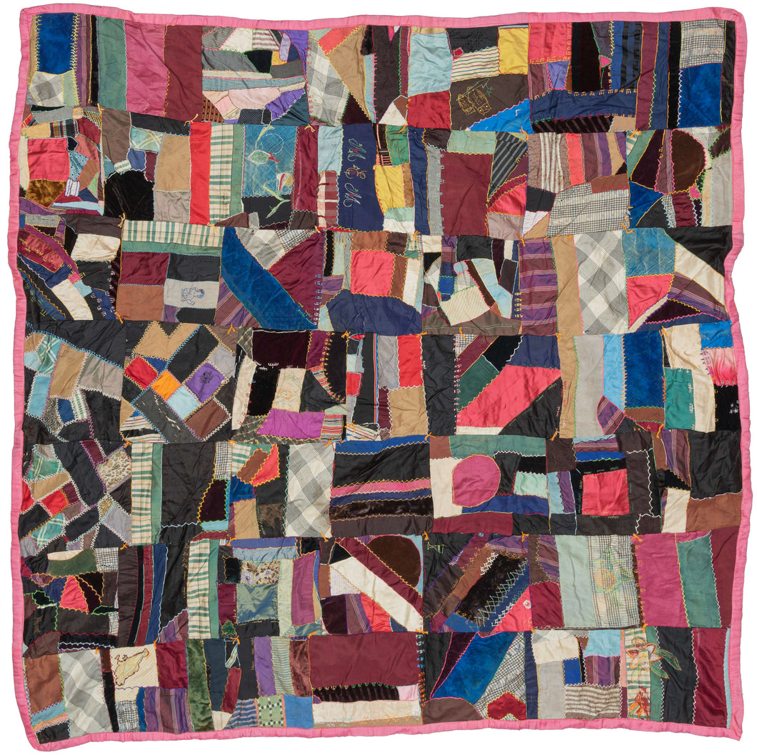 19th century American crazy quilt. This particular quilt is composed of pieced together fabrics, sewn together with a decorative feather stitch. Very cheerful and fun, with polychrome stitching being and a variety of fabrics. The main colors in the fabrics are reds, blues, and grays. . Various flowers, a simple bird and the initials 