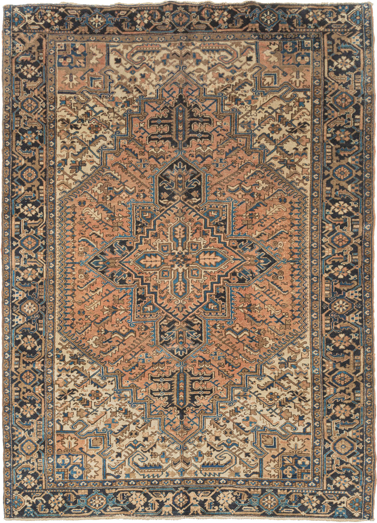 It features the classic Heriz design of a graphic geometric central medallion. The navy medallion is flanked by two lovely teardrop medallions on a terracotta field and surrounded by four ivory cornices. The cornices flow into one other on the top and bottom giving the field an elegant almond shape. Appealing touches of turquoise, coral and caramel add interest. The main border is composed of a reciprocating palmette on a deep navy ground which perfectly frames the composition.