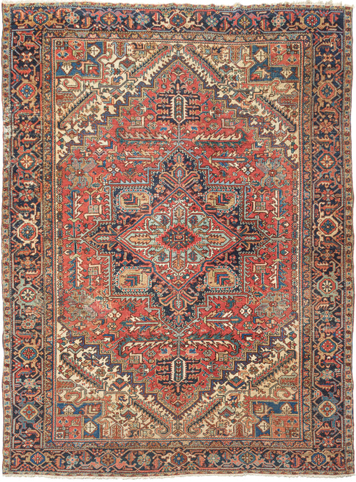 This ﻿Heriz rug was handwoven in Northwest Iran during the second quarter of the 20th century.  This classic Heriz features a geometric central medallion on a madder red ground. The four cornices loosely mirror the field design in a different color combination with the use of ivory working to light the composition. The inclusion of marled yarn palmettes  and 